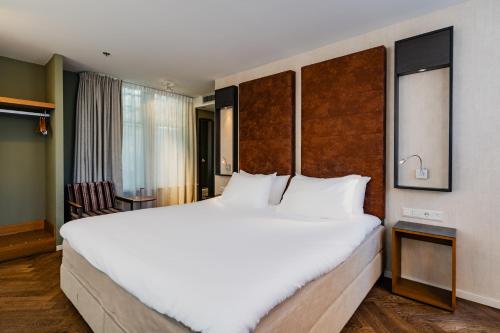 阿姆斯特丹哈伦酒店的一张大白色的床,位于酒店客房内
