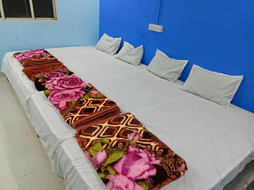 乌贾因M Baba Guest House的一张大床,上面有毯子