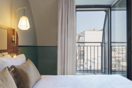 克利希voco Paris - Porte de Clichy, an IHG Hotel的酒店客房设有一张床和一个大窗户