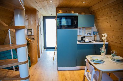 XertignyDomaine de la vôge & chalets et spa的厨房配有蓝色冰箱和桌子
