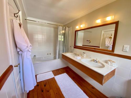 开普敦阿考恩楼旅馆的一间带水槽、浴缸和镜子的浴室