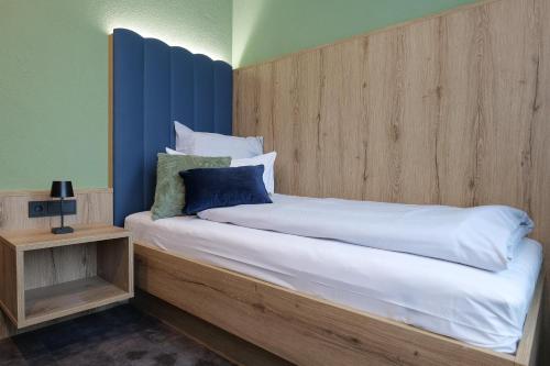 阿尔戈伊地区伊斯尼Reos Hotel Isny的一间卧室配有一张大床和木制床头板