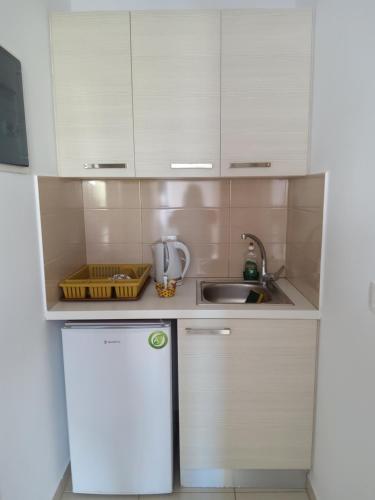 安迪帕罗斯岛Theologos Beach的厨房配有白色橱柜、水槽和冰箱。