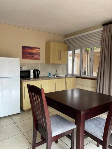 德班African Oyster的厨房配有桌椅和冰箱。