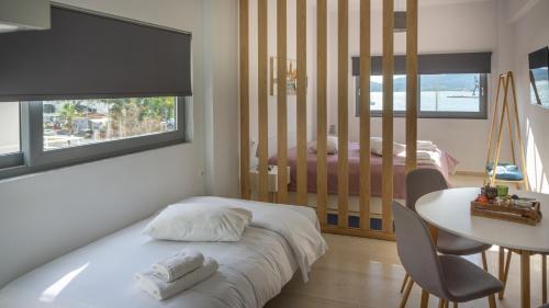 沃洛斯Nest Port View Apartment的卧室配有1张床、1张桌子和1张桌子以及椅子。