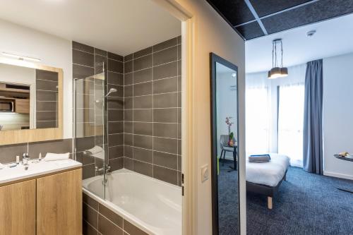 尼斯Nemea Appart Hotel Nice Arenas Aéroport的带浴缸和盥洗盆的浴室
