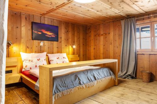 厄茨Liberty Ranch Marlstein的卧室配有一张床铺,位于带木墙的房间内