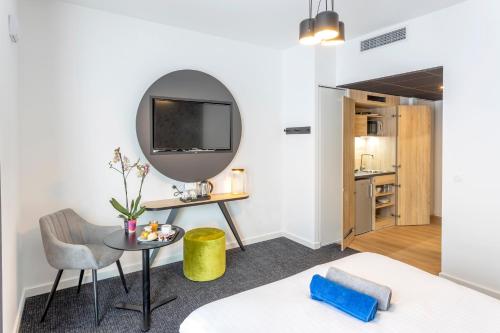尼斯Nemea Appart Hotel Nice Arenas Aéroport的客房设有床、桌子和镜子