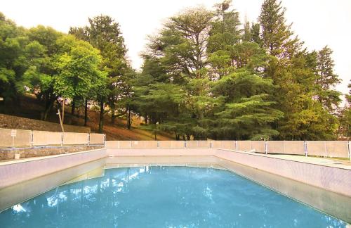 比亚莱特马西Complejo Turistico - Hotel Pinar serrano - Bialet Masse - Cordoba的一片蓝水,有树在后面