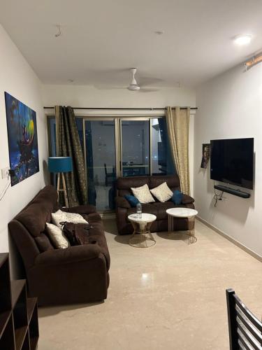 孟买Room in Flat with Amazing City and Sea View的带沙发和平面电视的客厅