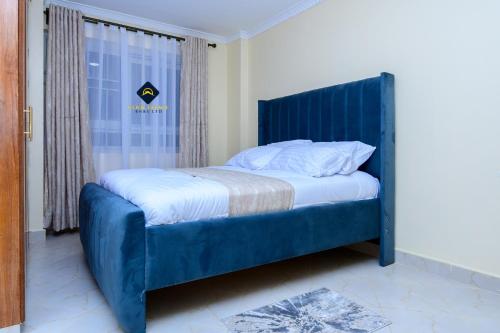 内罗毕Jalde Heights, Limuru Road, 178, Nairobi City, Nairobi, Kenya的一张带蓝色床头板的睡床
