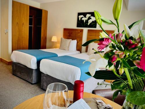 都柏林贝雷斯福德酒店的配有两张床和鲜花的旅馆客房