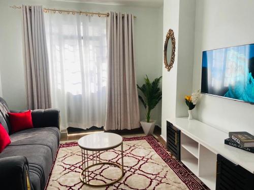 内罗毕Garden estate Thika road furnished home的客厅配有沙发和桌子