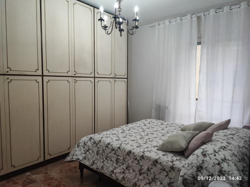 米兰CASA DI LORY的一间卧室配有一张带白色橱柜和吊灯的床。