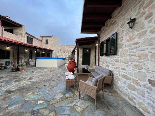 海若克利欧Pyrgou Villa with Shared Swimming pool的一个带椅子和石墙的庭院
