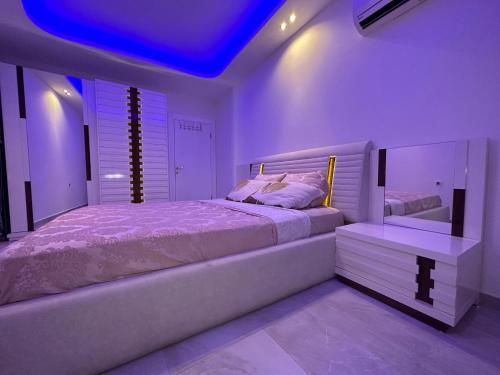阿拉尼亚Lumos SPA ALL-IN apartment in Luxury resort full facilities的一间卧室设有一张大床和蓝色的天花板