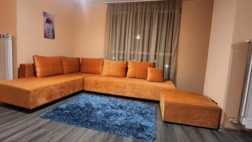 PernikЕлегантен градски апартамент с обширна тераса的客厅配有棕色沙发和蓝色地毯。