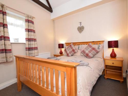 海布里奇1 bed in Burnham-on-Sea ALPAD的一间卧室配有一张木床和两盏灯。