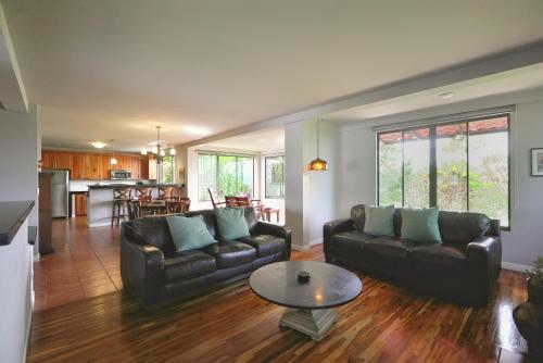 阿拉胡埃拉Villas Aracari的客厅配有两张真皮沙发和一张桌子