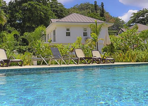 博瓦隆Las Brisas Villa - Chateau Elysium的一个带椅子的游泳池以及一座房子