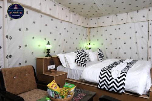 斋沙默尔Khamma Ghani Jaisalmer的一间卧室配有一张带黑白枕头的床