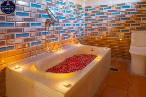斋沙默尔Khamma Ghani Jaisalmer的浴室设有装满红胡椒的浴缸。
