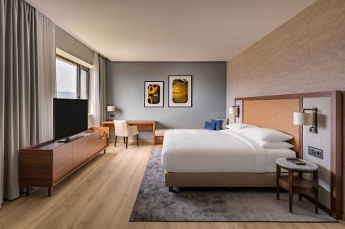 日内瓦Geneva Marriott Hotel的配有一张床和一台平面电视的酒店客房