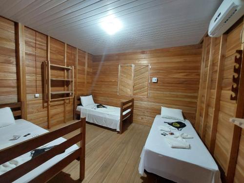 CareiroAmazon Seringal jungle Lodge的木墙客房 - 带两张床