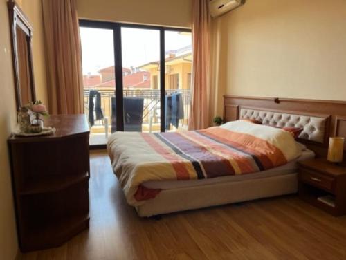 金沙Apartment Golden Sands and Black Sea, Varna的一间卧室配有一张床、一个梳妆台和一扇窗户。