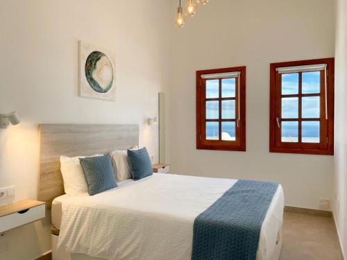 蒂亚斯Villa Livia Oceanwiew Quiet Eco的一间卧室设有一张床和两个窗户。