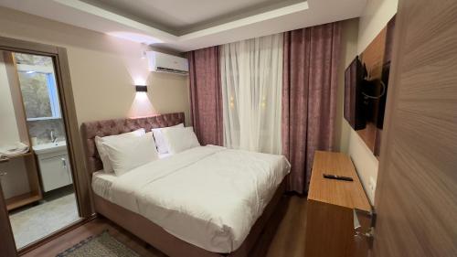 伊斯坦布尔Golden Tulip Suite Apart的卧室配有白色的床和窗户。