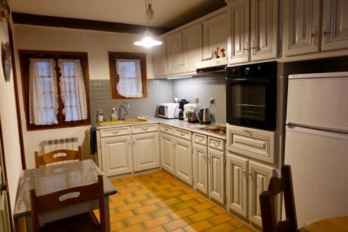 圣吉扬莱代塞尔CHARMANTE MAISON A SAINT GUILHEM LE DESERT的厨房配有白色橱柜和黄色瓷砖地板。