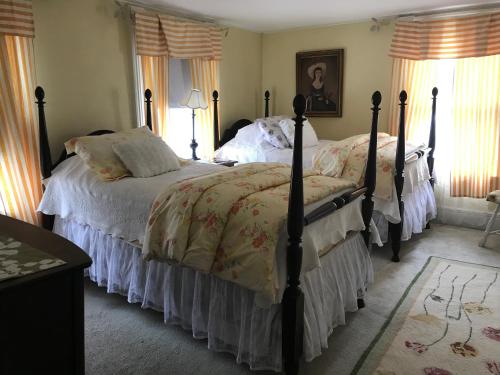 Jaffrey莫纳德诺克旅馆（Monadnock Inn）的一间卧室配有两张带白色棉被的床