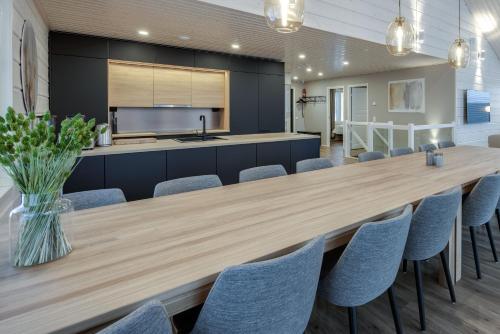 耶姆赛Luksushuvila Himos Hillside的大型用餐室配有大型木桌和椅子
