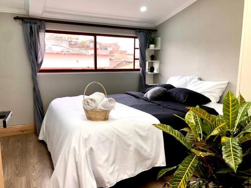 昆卡Family Apartment centro ciudad + Netflix的一间卧室,配有一张床和一个桌子上的篮子