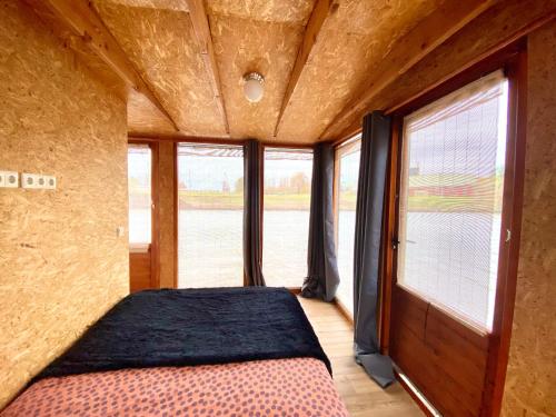 乌得勒支Off-Grid Boat Experience - Stay Zero Footprint的一间设有床铺的卧室,位于带窗户的房间内