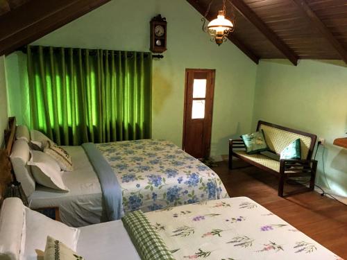 RangalaThe Vintage Villa - Knuckles的一间卧室设有两张床,窗户设有绿色窗帘