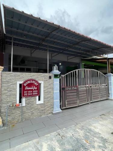 马六甲Homestay ShimahJay Telok Mas Melaka的一座建筑,上面有门和标志