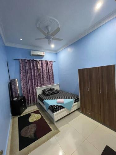 马六甲Homestay ShimahJay Telok Mas Melaka的一间卧室配有一张床和吊扇