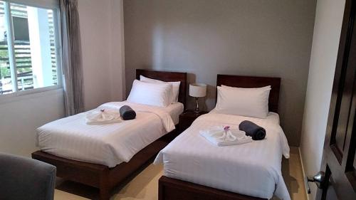 Phra Ae beach2 Bedroom Seaview Lanta Sport Resort 303的配有白色床单的酒店客房内的两张床