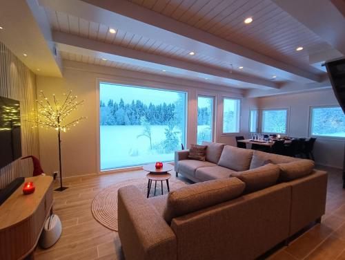 UurainenMökki ulkoporealtaalla的带沙发和大窗户的客厅