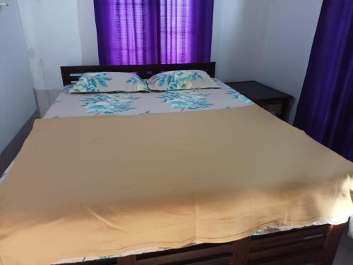 AnachalMunnar Hills & Mist View的一间卧室配有蓝色窗帘的床
