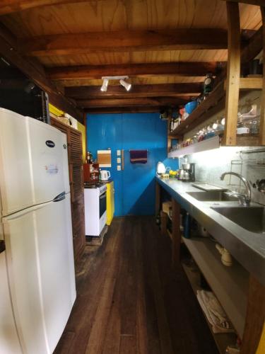 La AguadaCasa Encantada Guest House的厨房配有白色冰箱和蓝色的墙壁