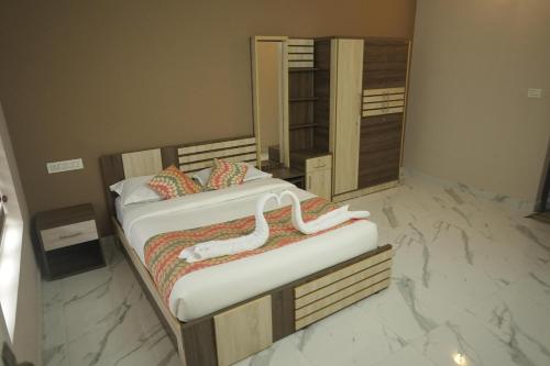 瓦亚纳德Luxe Hotel - Rooms & Villas Wayanad的卧室设有两张床,铺有大理石地板。