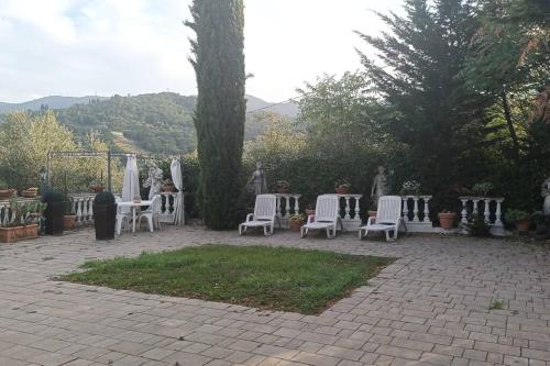 SeanoCasa tranquilla colonica toscana vicino a Firenze的庭院里摆放着一组白色的桌椅