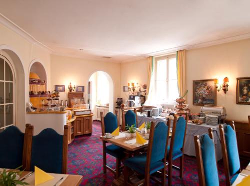 萨尔茨堡卡瑟勒布劳老城区酒店的一间带桌子和蓝色椅子的用餐室