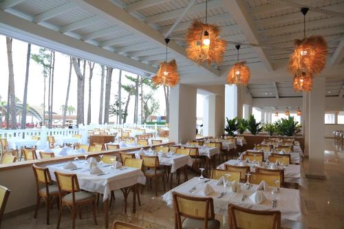 贝尔迪比Siu Collection的餐厅设有白色的桌椅和吊灯。