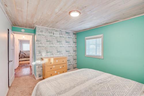西德尼Sidney Vacation Rental with Fenced-In Yard!的一间卧室设有一张床和砖墙