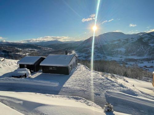 松达尔Cabin at the top of Hodlekve. Ski in/ski out.的享有雪覆盖的滑雪场和灯光的景色