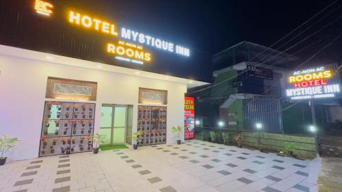 维特利Mystique Inn Wayanad的一间商店,上面有两扇门和 ⁇ 虹灯